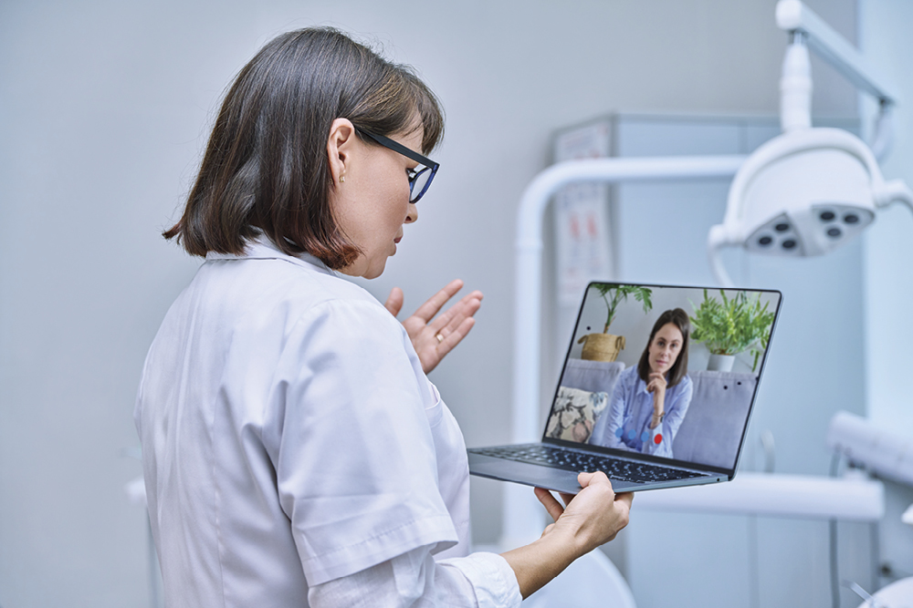 A physician talking to a patient on her laptop