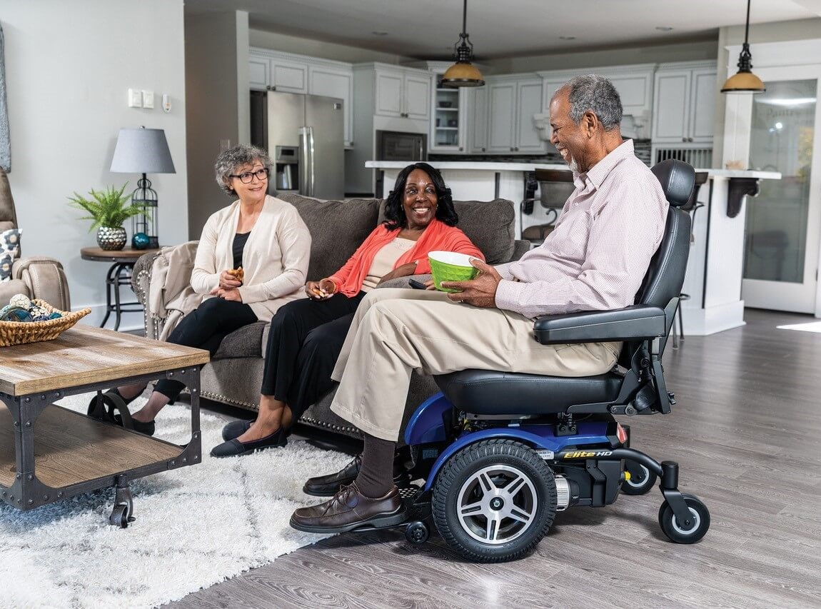 Man using powered mobility while visiting with others