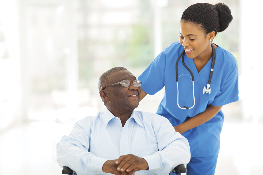 African nurse taking care of senior patient in wheelchair