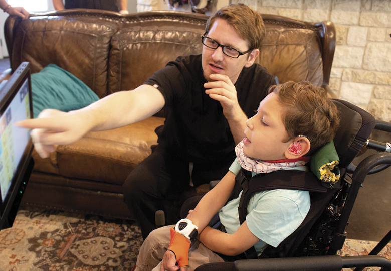 Male pointing at speech generating device