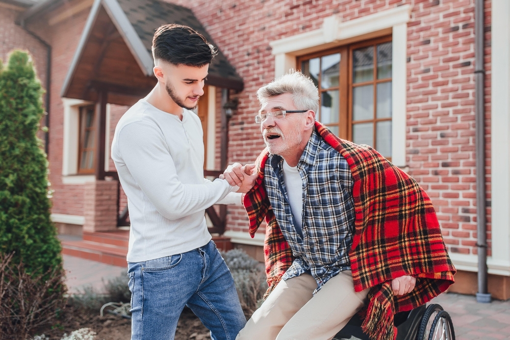 younger man helping older up out of chair