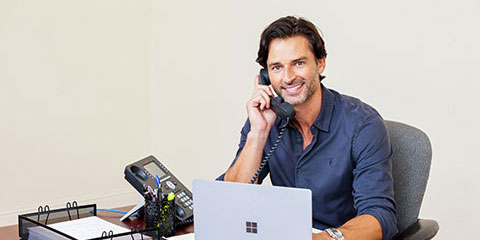 male on the phone at his desk
