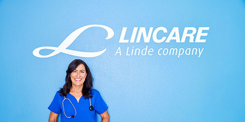 Lincare employee in front of a Lincare sign