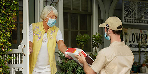 a woman receiving a package at her front door 