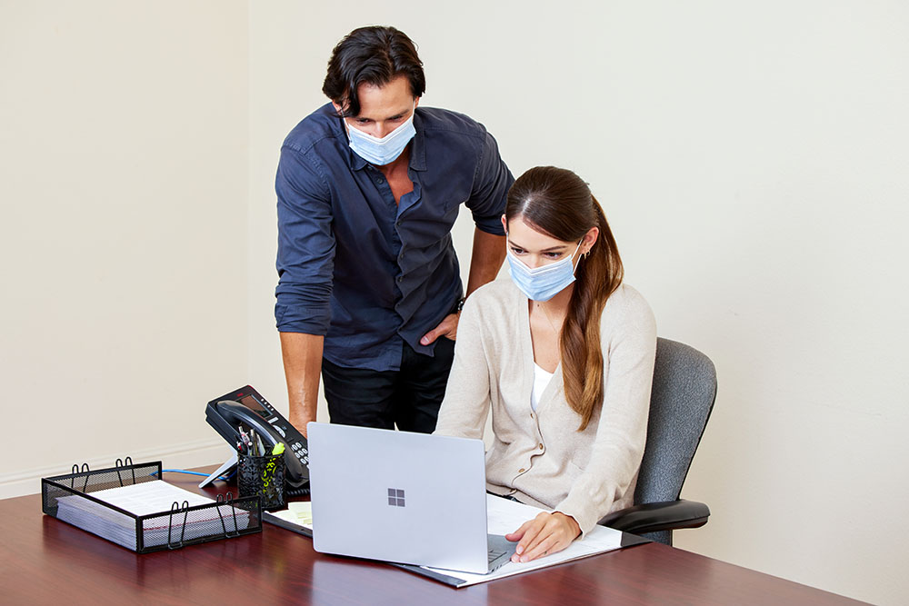workers at desk on computer together