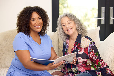 clinical employee looking at book with patient on the couch