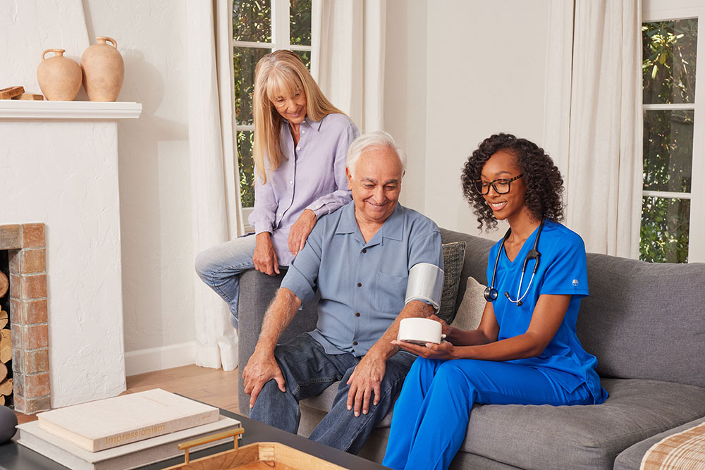 clinical employee taking blood pressure of patient on the couch