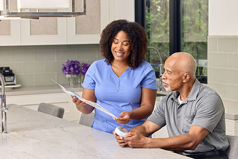 INR BlackFemaleClinicianBlackMalePatient SittingInKitchen RocheINRTestingMonitorBrochure2