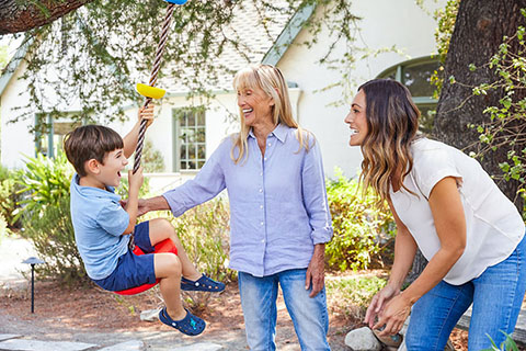 Lifestyle FamilyPushingChildOnSwing Outside Smiling2