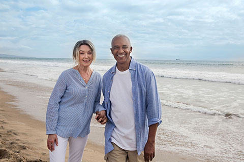 Lifestyle WhiteFemaleBlackMale BeachWalkingLookingAtCamera