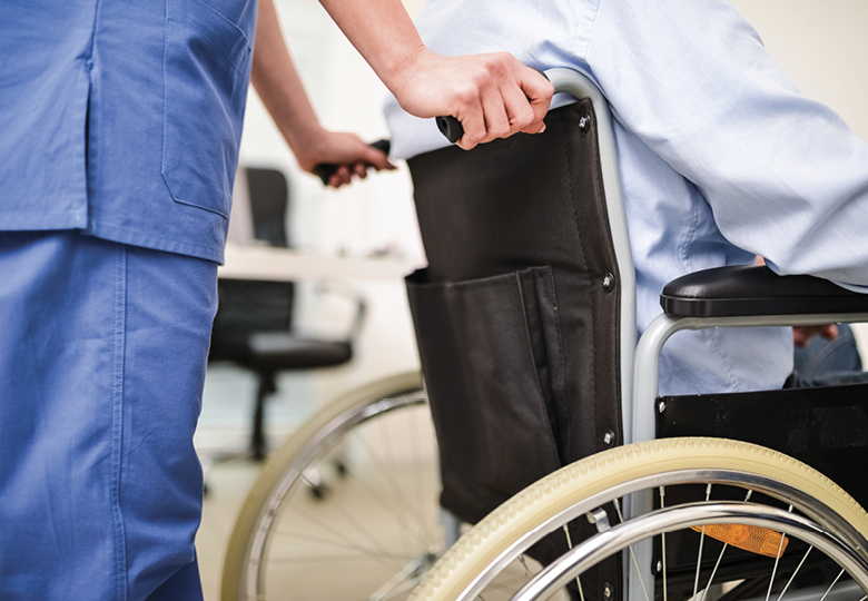 medical employee pushing patient in a wheelchair