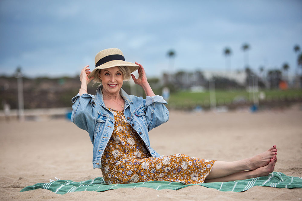 Lifestyle WhiteFemale BeachBlanketPuttingonHat