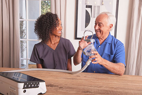 Non Invasive Vent NHV BlackFemaleClinicianWhiteMale SittingAtDiningTable Ventilator Luisa2