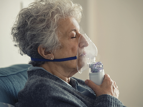 woman using nebulizer with mask