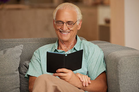 Oxygen WhiteMale SittingOnCouchReading NasalCannula