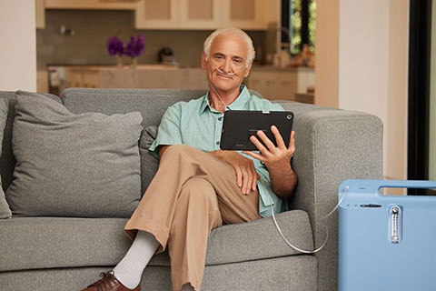 Oxygen WhiteMalePatientHoldingATablet RespironicsEverfloOxygenConcentrator