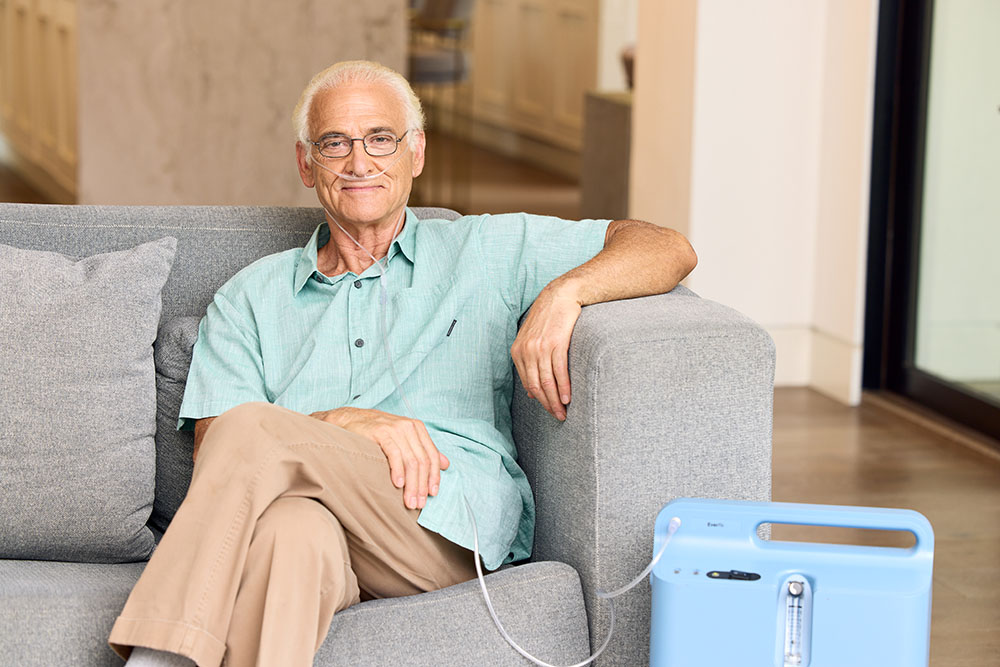 Oxygen White Male Sitting on Couch Oxygen Concentrator Respironics Everflow 5LPM 2