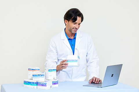 Male Pharmacist with Laptop Holding Unit Dose Medications