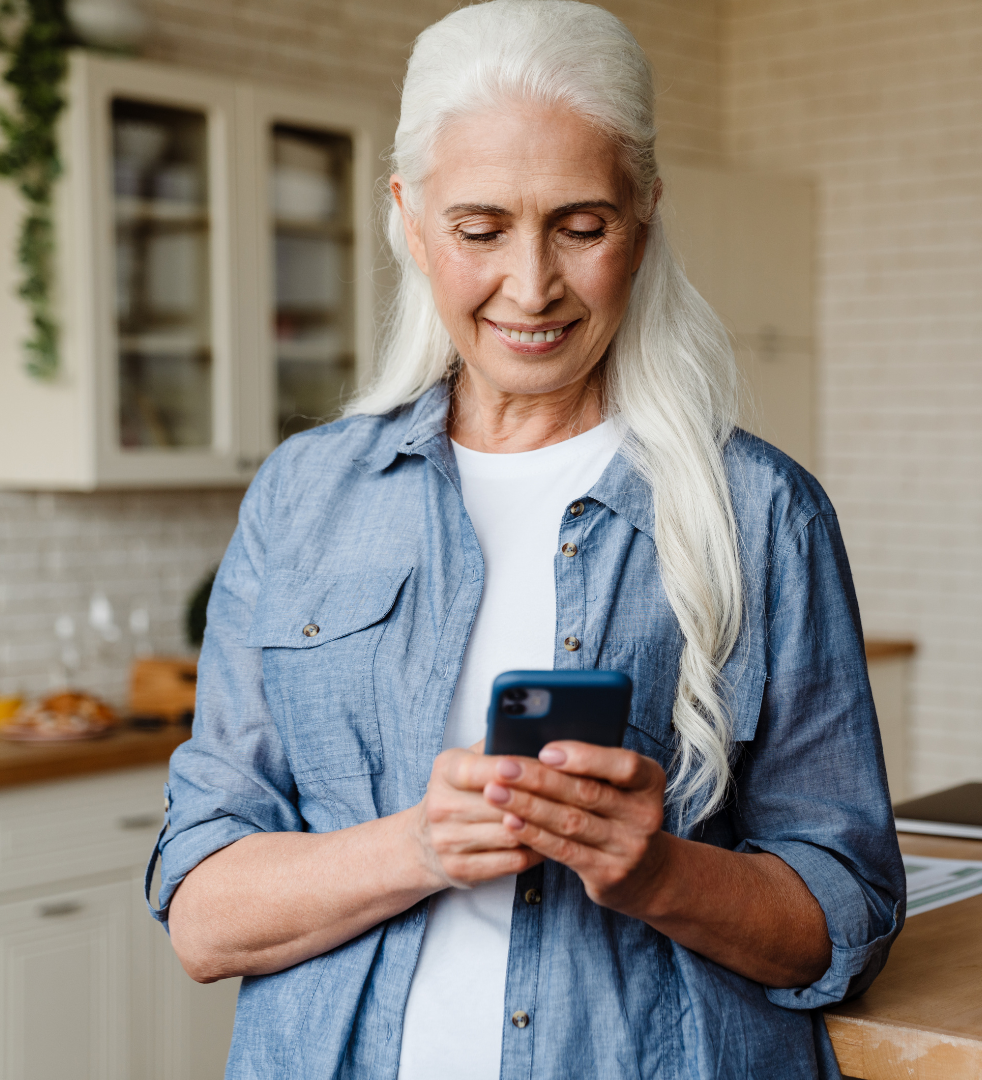 woman with white hair looking at her mobile phone