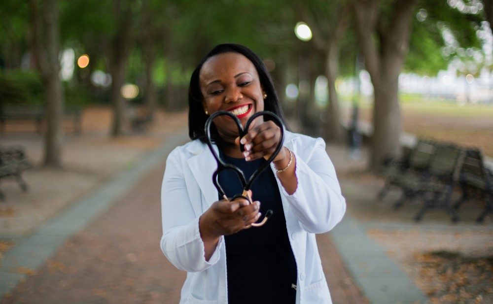 woman holding a stethoscope in the shape of a heart