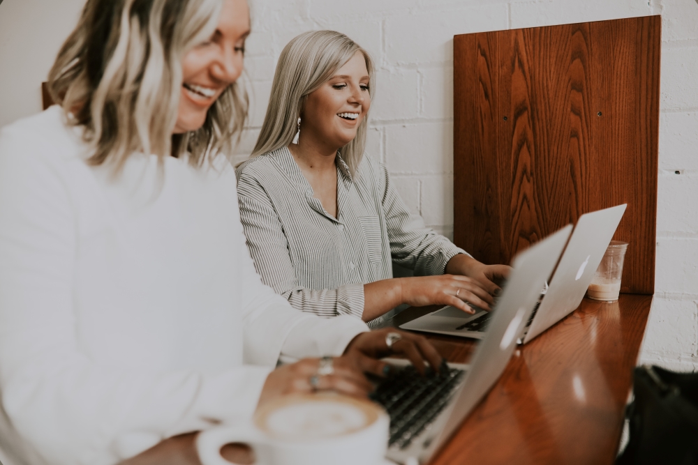 ladies working on their laptops side by side