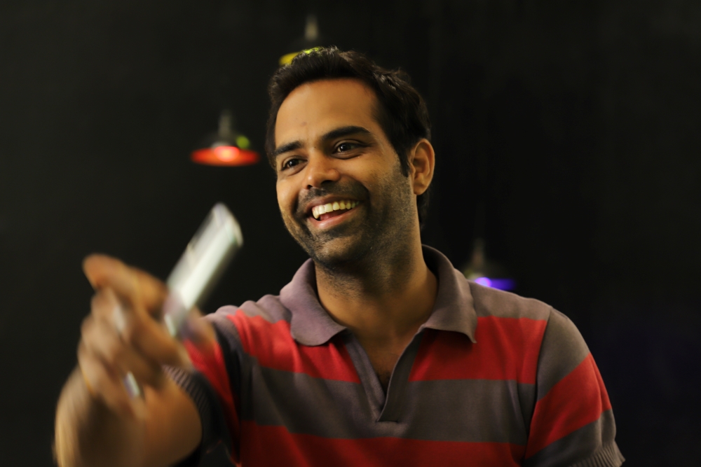 man smiling and pointing with phone in hand
