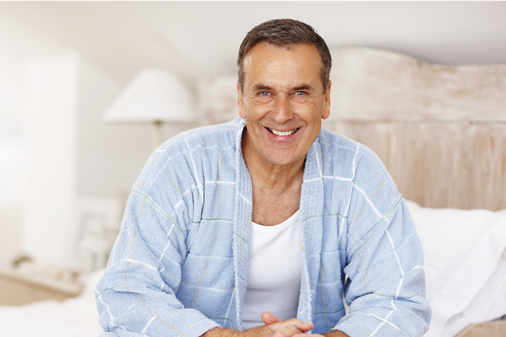 Man wearing robe while sitting in bed