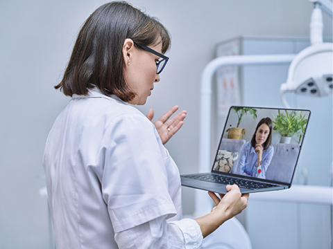 A physician talking to a patient on her laptop