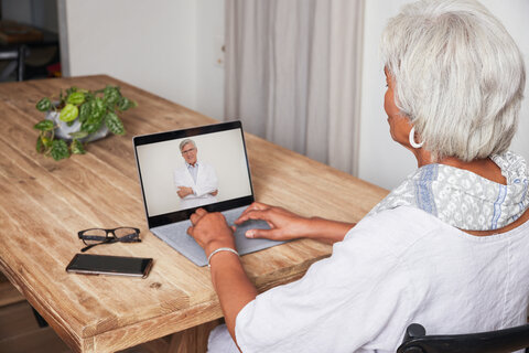 Telehealth Black Older Female Dining Room on Laptop with Doctor