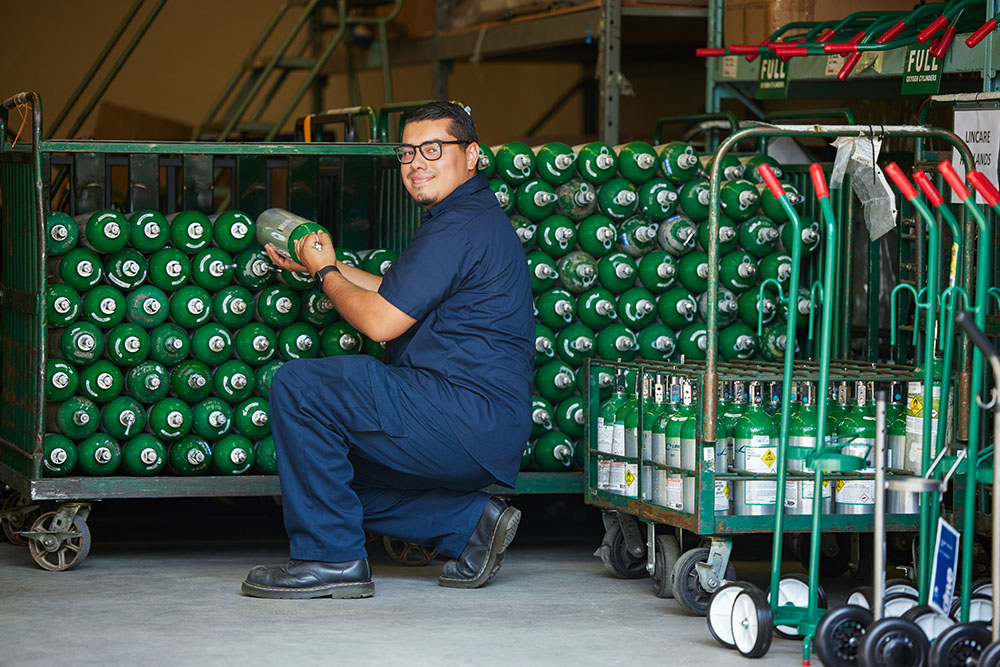 Hispanic Male Grabbing Oxygen Cylinders