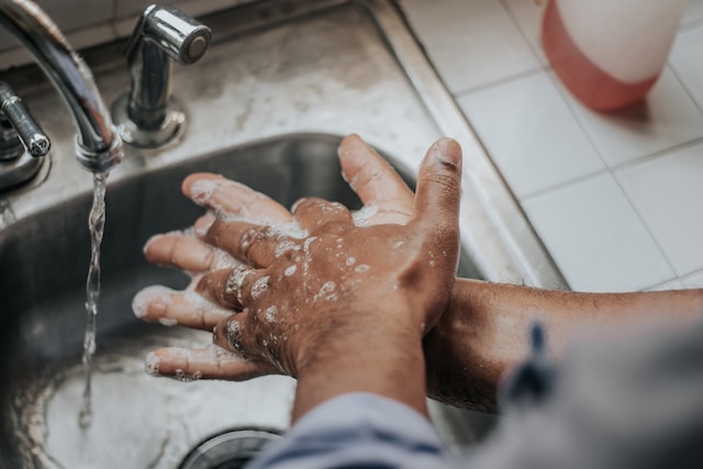 a person washing their hands in a sink