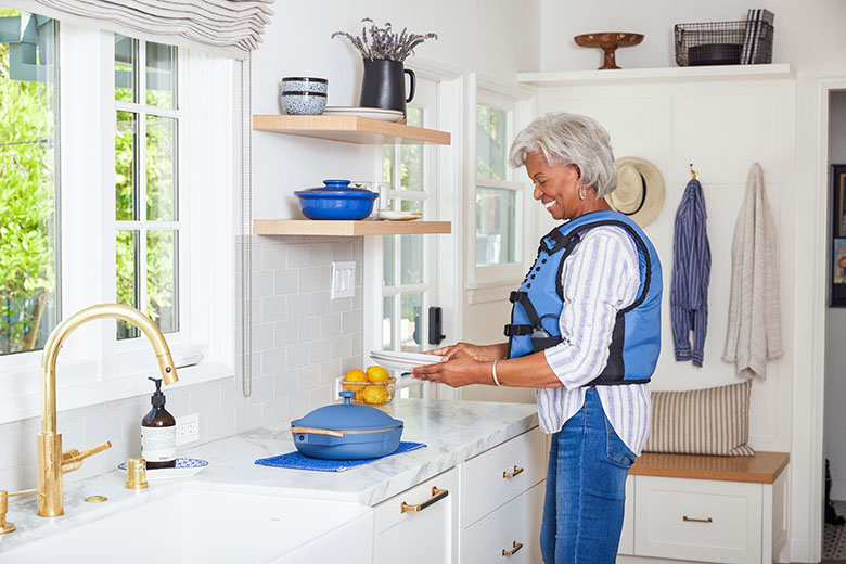 woman wearing HFCWO vest in her kitchen