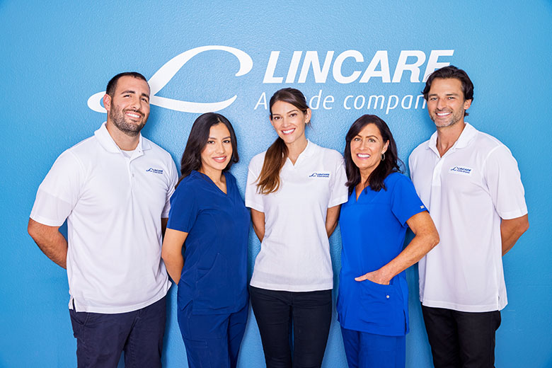 Lincare employees standing in front of a Lincare sign