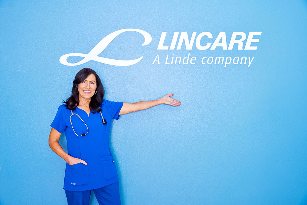 female lincare worker in front of lincare sign