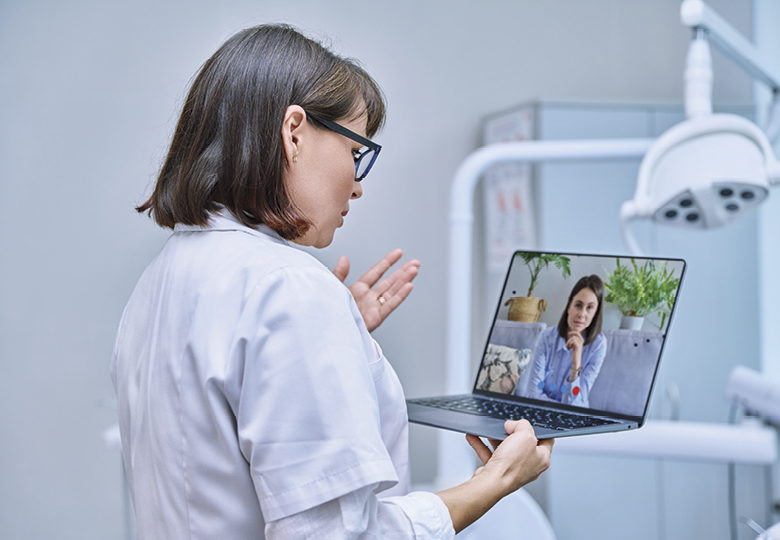 A physician talking to a patient on her laptop