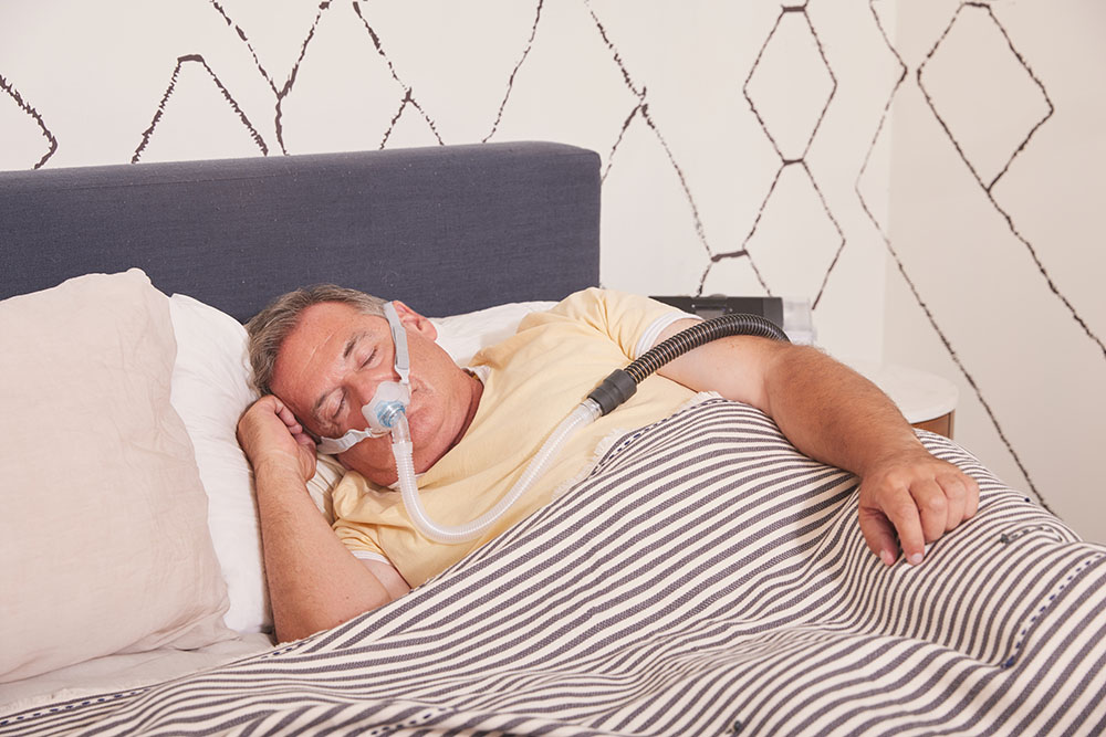 Sleep Apnea Heavy Set White Male Sleeping with Pap PAP Mask Pap Machine Brevida Fisher and Paykel